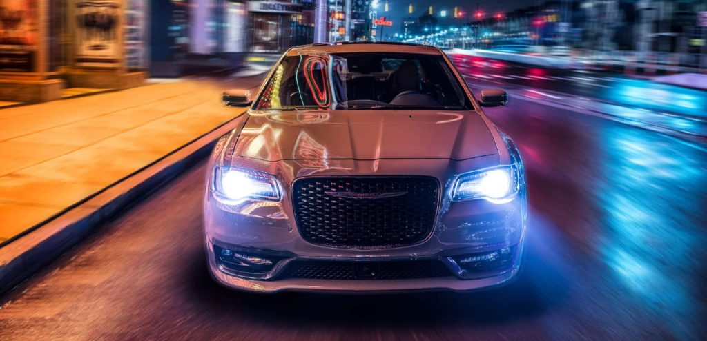 2023 White Chrysler 300 driving on a city streets with led lights illuminated