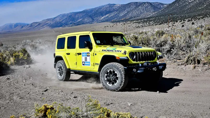 2024 Jeep® Wrangler Rubicon X 4xe Driving Through a Desert for Rebelle Rally Front 3/4 View