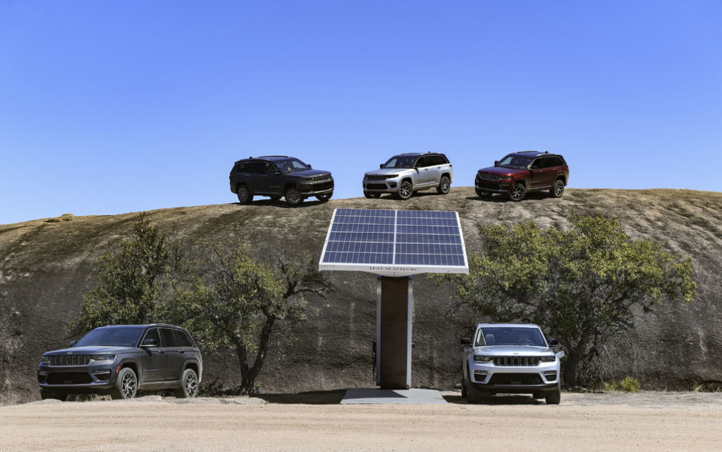 Five Jeep SUVs Parked on a Hill Around a Solar Panel