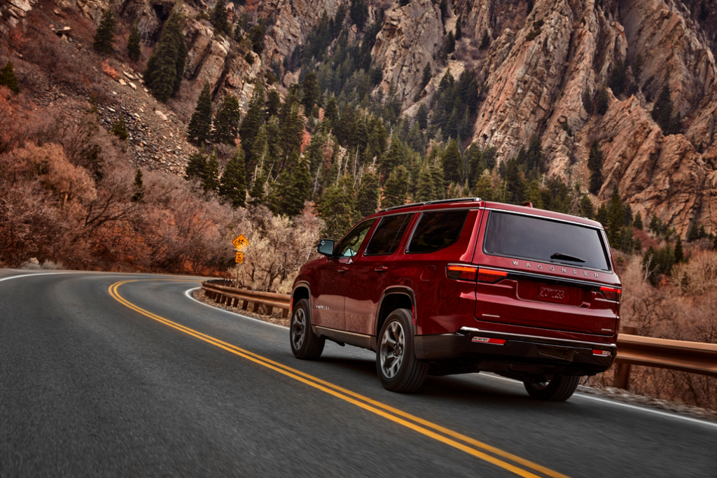 Jeep Wagoneer Driving on a Mountain Road Rear 3/4 View