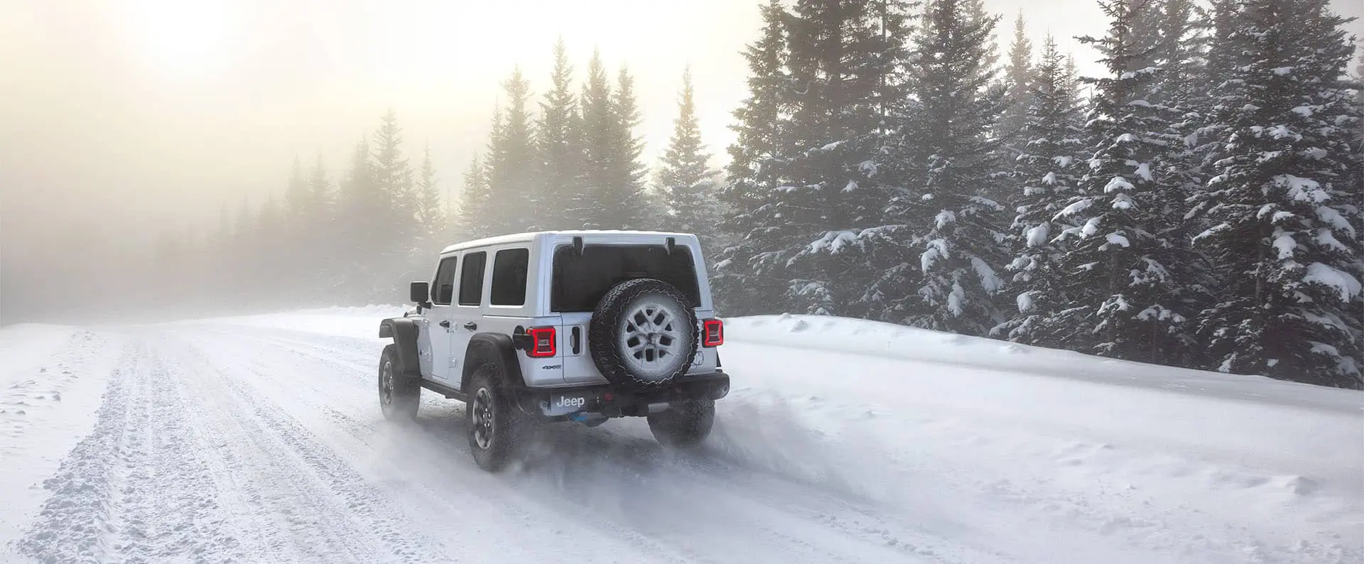 2025 Jeep Wrangler 4xe Rear View on a Snow Covered Road