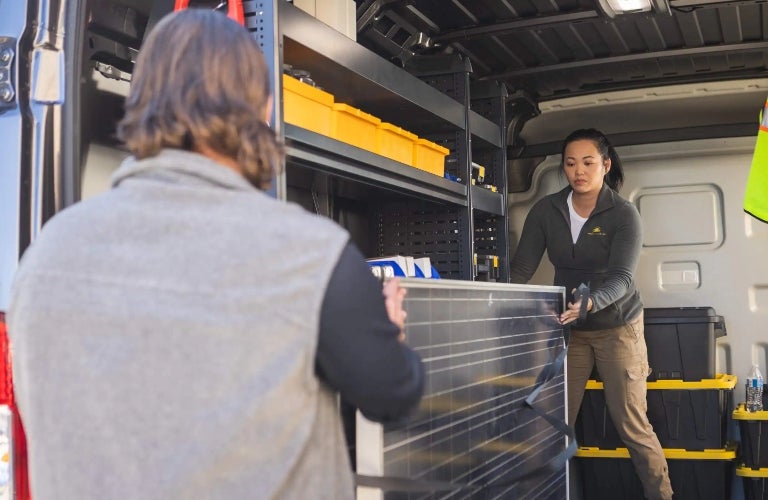 workers loading items in cargo area of Ram ProMaster
